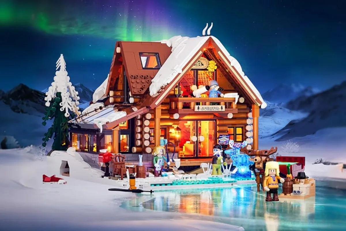 Beleuchtetes Klemmbaustein-Set Winter: Verschneite Blockhütte mit Nordlicht-Hintergrund.